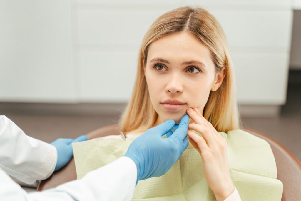 Woman at a dental appointment discussing possible gum disease symptoms without bleeding gums during a preventive oral health examination.