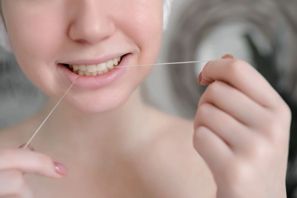 Keep Teeth Healthy with a Busy Lifestyle by flossing daily to remove plaque between teeth and support healthy gums as part of a simple preventive oral care routine.