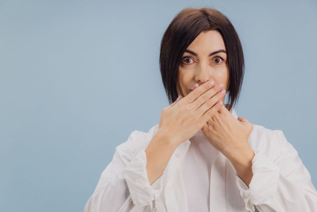 Woman covering her mouth due to persistent bad breath
