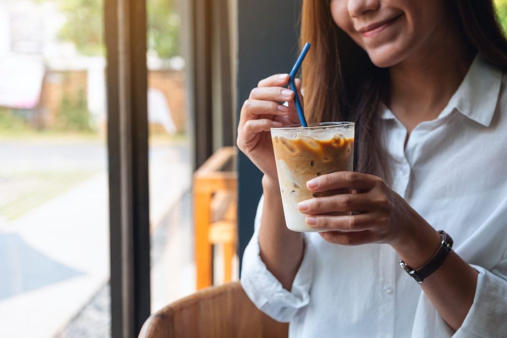 Woman drinking iced coffee after teeth whitening treatment in Maitland, FL